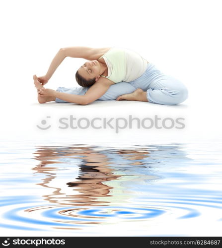 lovely girl practicing ashtanga yoga on white sand