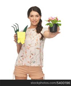 lovely housewife with flower in pot and gardening set