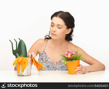 lovely housewife with flower in pot and gardening set