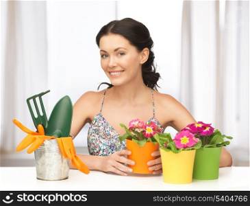 lovely housewife with flower in pot and gardening set