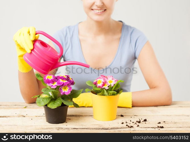 lovely housewife with flower in pot and watering can