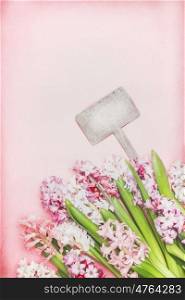Lovely Hyacinths flowers with bokeh and blank wooden sign on pink background, top view. Springtime and gardening concept