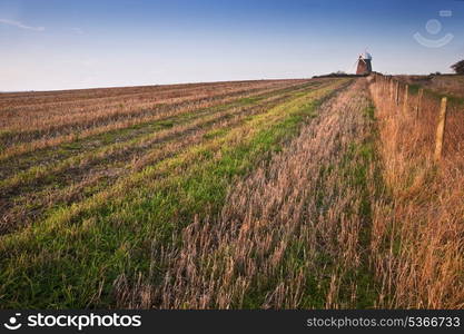 Lovely image of old windmill at sunset on top of hill