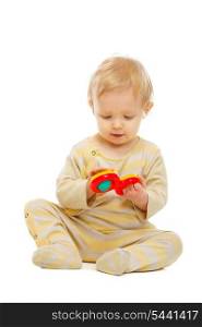 Lovely kid playing with rattle on floor isolated on white