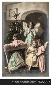 Lovely kids with white angels wings and christmas tree. vintage picture with original film grain and blur