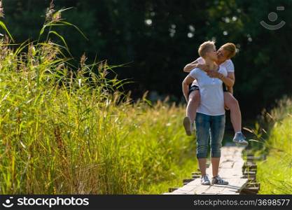 Lovely lesbian couple are piggyback together, sunny day