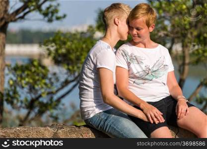 Lovely lesbian couple together in privacy, sunny summer day