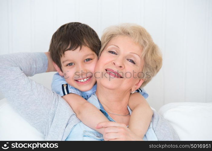 Lovely little boy with his grandmother having fun and happy moments together at home