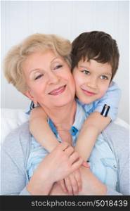 Lovely little boy with his grandmother having fun and happy moments together at home