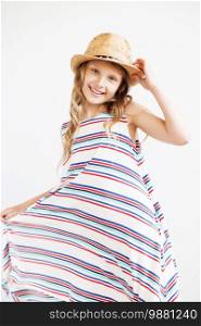 Lovely little girl in straw hat against a white background. Smiling summer kids