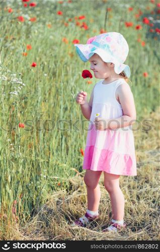 Lovely little girl in the field of wild flowers. Cute girl picking the spring flowers for her mom for Mother's Day in the meadow. Spending time close to nature