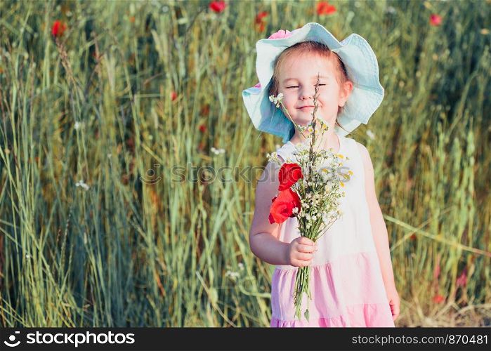 Lovely little girl in the field of wild flowers. Cute girl picking the spring flowers for her mom for Mother's Day in the meadow. Spending time close to nature