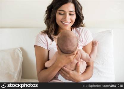Lovely mother holding newborn baby in arms