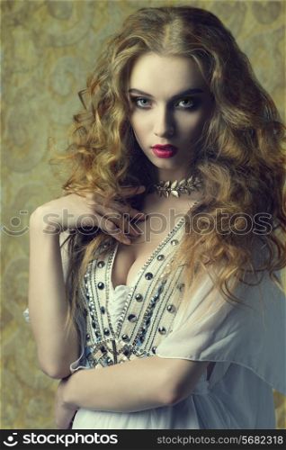 lovely sensual woman wearing antique clothes and jewellery and posing with long curly hair. fashion vintage portrait