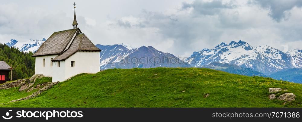 Lovely small old Church in Bettmeralp Alps mountain village, Switzerland. Summer cloudy panorama view.