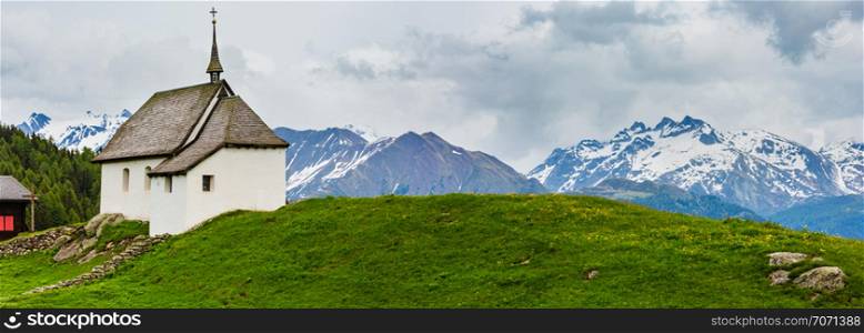 Lovely small old Church in Bettmeralp Alps mountain village, Switzerland. Summer cloudy panorama view.