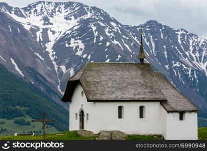 Lovely small old Church in Bettmeralp Alps mountain village, Switzerland. Summer cloudy view.