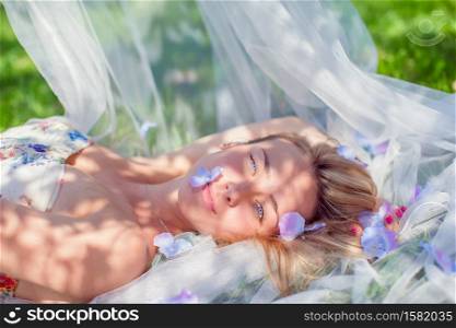 Lovely tender pregnant woman relaxes resting on the grass in the park on a warm day. Pregnancy concept. Pregnant woman in outdoor park, warm weather