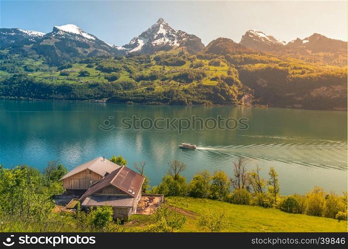 Lovely vacation destination in the Swiss Alps, around the Walensee lake. A spring scenery with mountains, lake, meadows and warm sun.