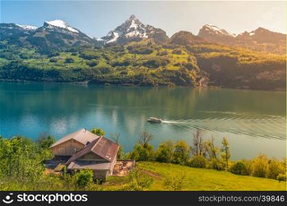 Lovely vacation destination in the Swiss Alps, around the Walensee lake. A spring scenery with mountains, lake, meadows and warm sun.