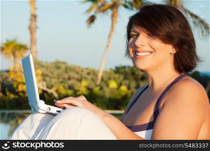 lovely woman with laptop computer at tropical resort