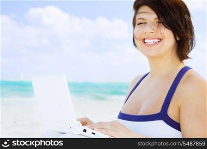 lovely woman with laptop computer on the beach