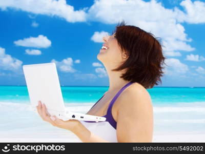 lovely woman with laptop computer on the beach