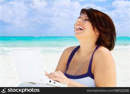lovely woman with laptop computer on the beach