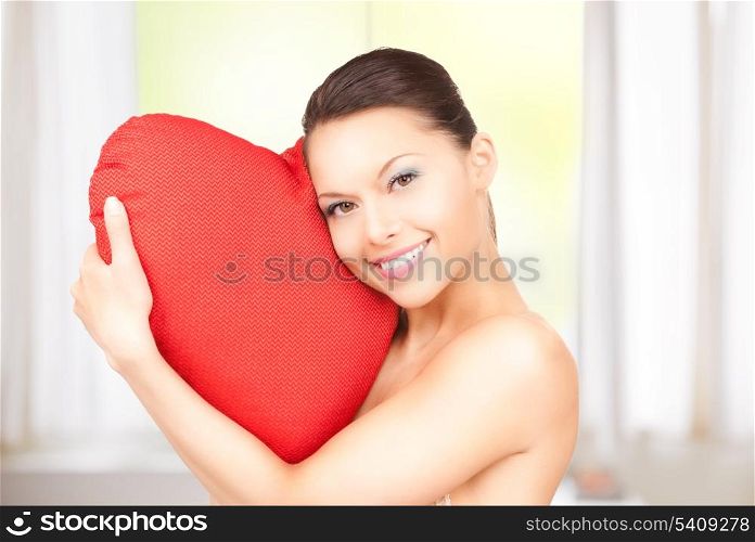 lovely woman with red heart-shaped pillow at home
