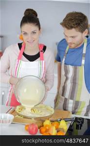 lovely young couple baking a cake