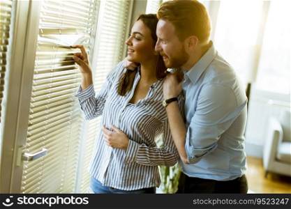 Lovely young couple by the window in the room on a sunny day