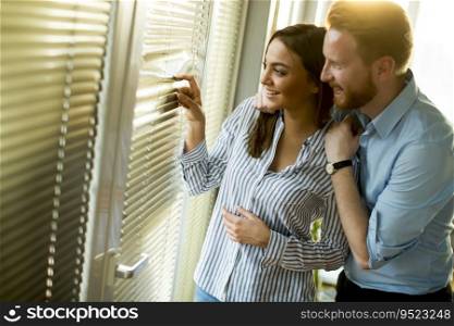 Lovely young couple by the window in the room on a sunny day