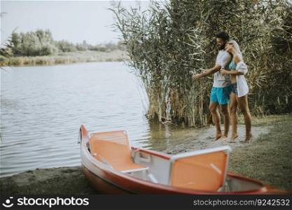 Lovely young couple enjoying fishing on sunny day at a calm lake