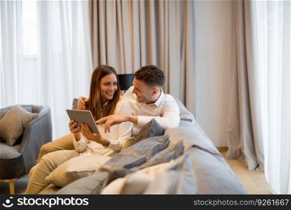 Lovely young couple with digital tablet in the room of an contemporary apartment