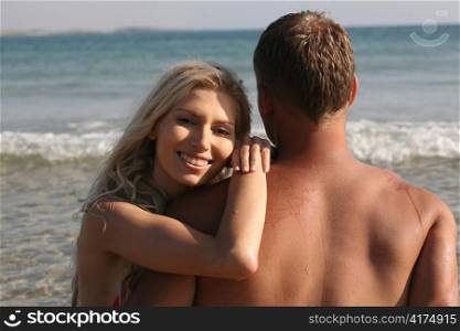 Lovely young female sitting with her boyfriend at the sea