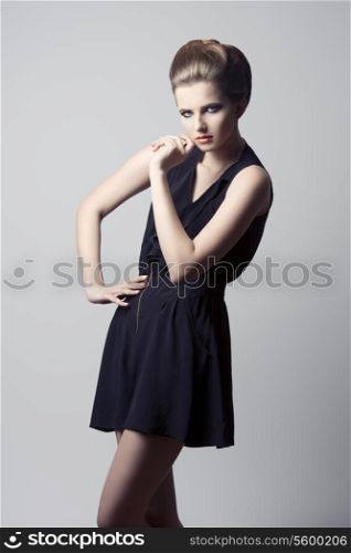 lovely young girl posing with charming fashion style, black dress, elegant hairdo and cute make-up.