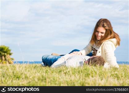 Lovers back in the grass next to the beach
