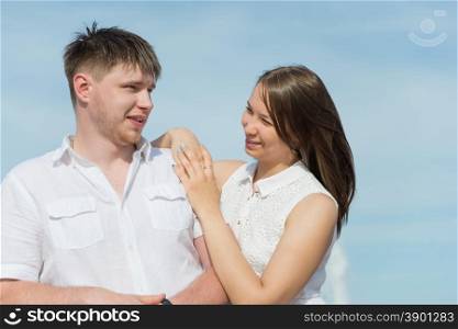 Lovers girl and boy hugging and looking at each other against the blue sky