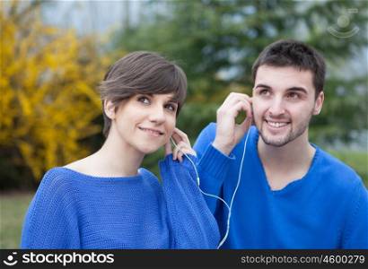 Lovers in the park dressed in blue listening to music with headphones&#xA;