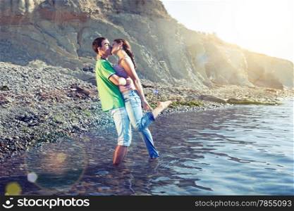 Lovers kissing passionately while standing ankle-deep in water