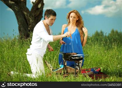 lovers on picnic cook steak