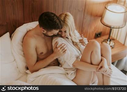 Loving and hugged couple on the bed in the room