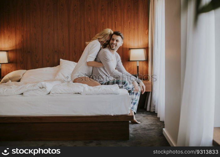 Loving and hugged couple on the bed in the room