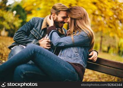 Loving and romantic couple on a bench in the autumn park