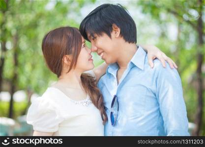 Loving asian couple under tree in the park