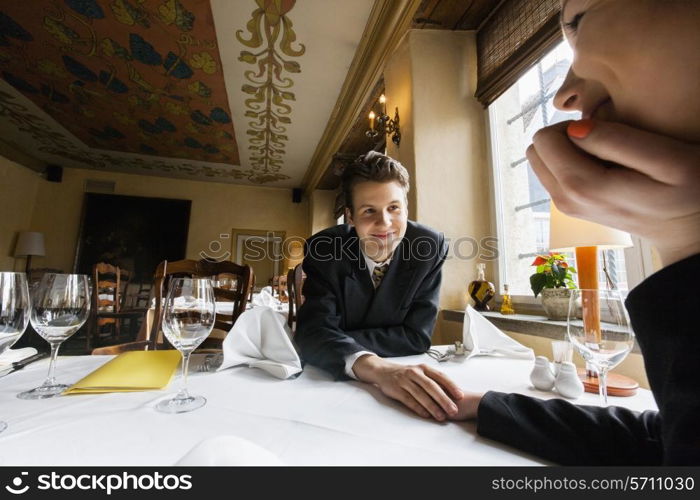 Loving business couple holding hands at restaurant table