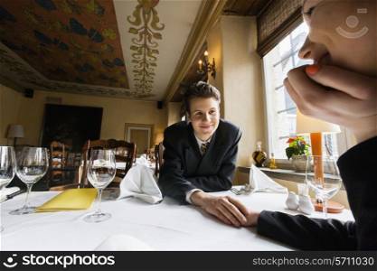 Loving business couple holding hands at restaurant table