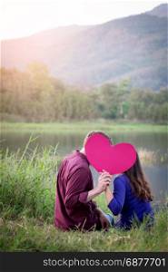 Loving couple. Beautiful young love couple holding paper hearts and smiling in outdoor nature vintage tone, valentine concept.