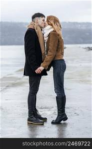 loving couple by lake during winter