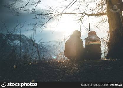 Loving couple enjoys the mountain view, beautiful scenery with sundown, autumn